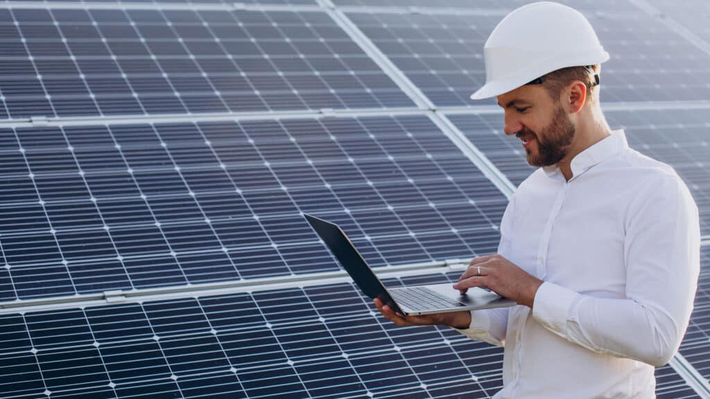 Standing by solar panels making diagnostics on computer